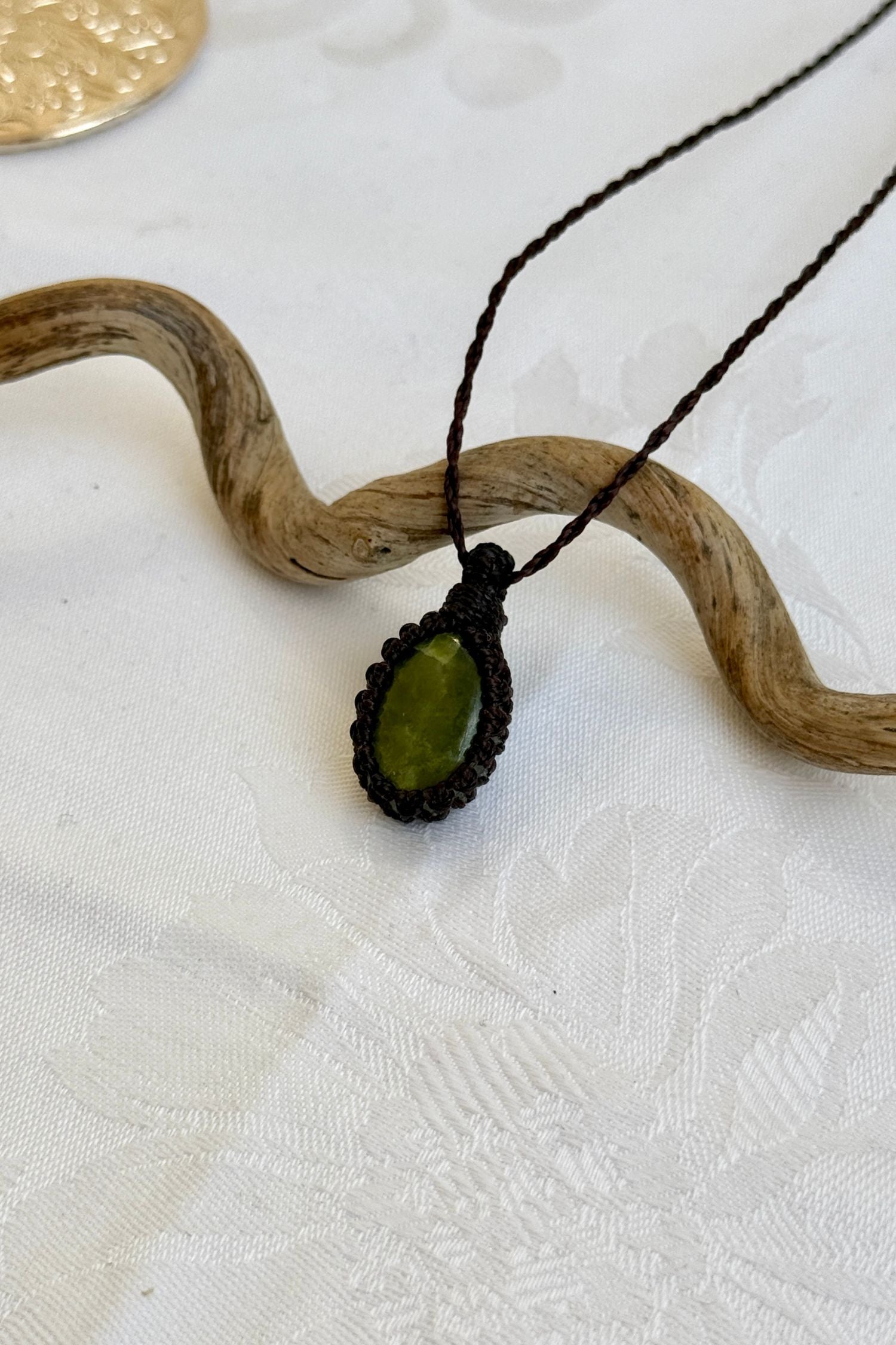 Side angle view of the Vesuvianite Macrame necklace, showing the fine macrame details and the unique gemstone centerpiece.