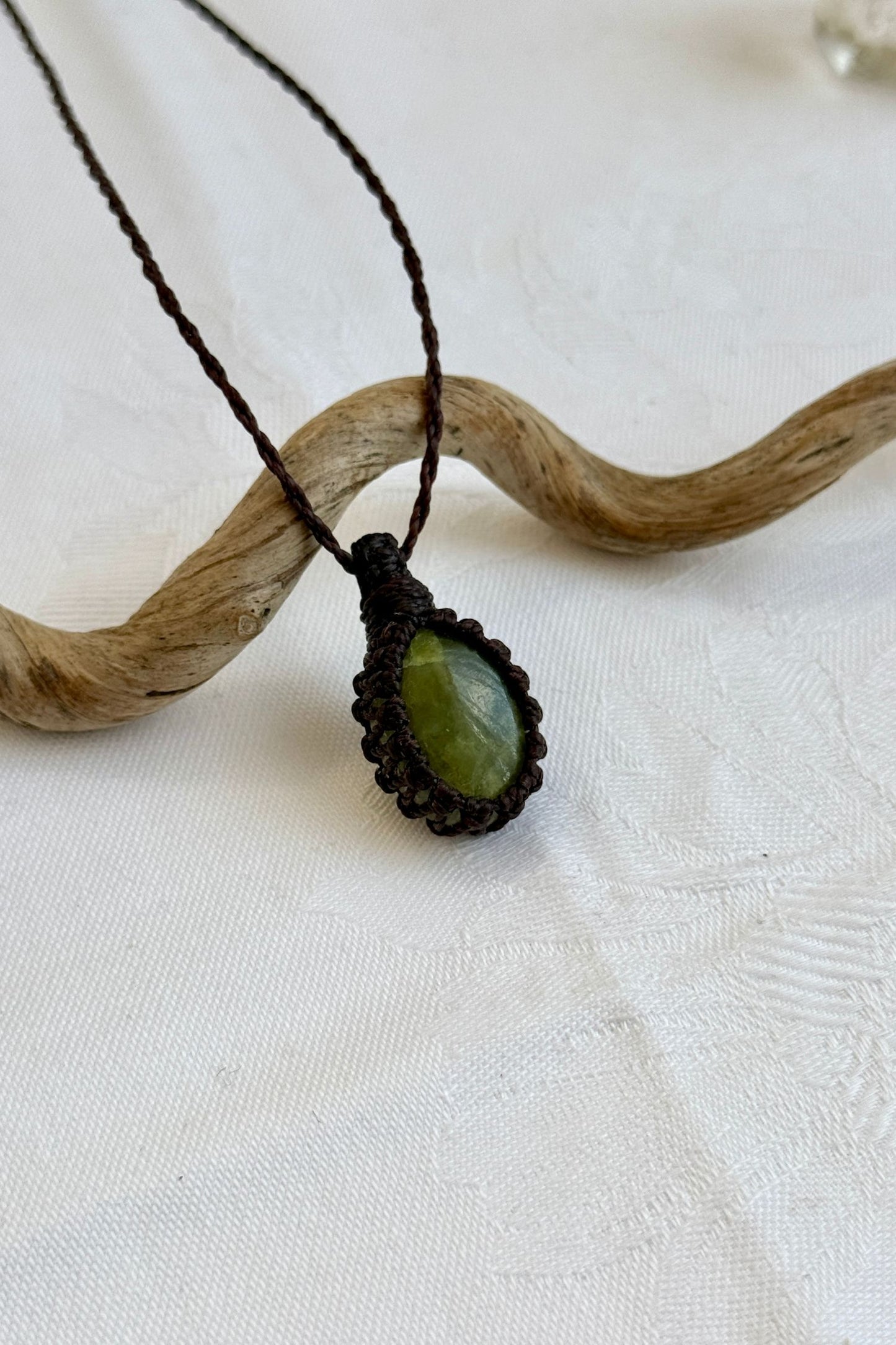 Close-up of handmade Vesuvianite Macrame necklace, showcasing the intricate macrame knotting and the vibrant patterns of the gemstone.