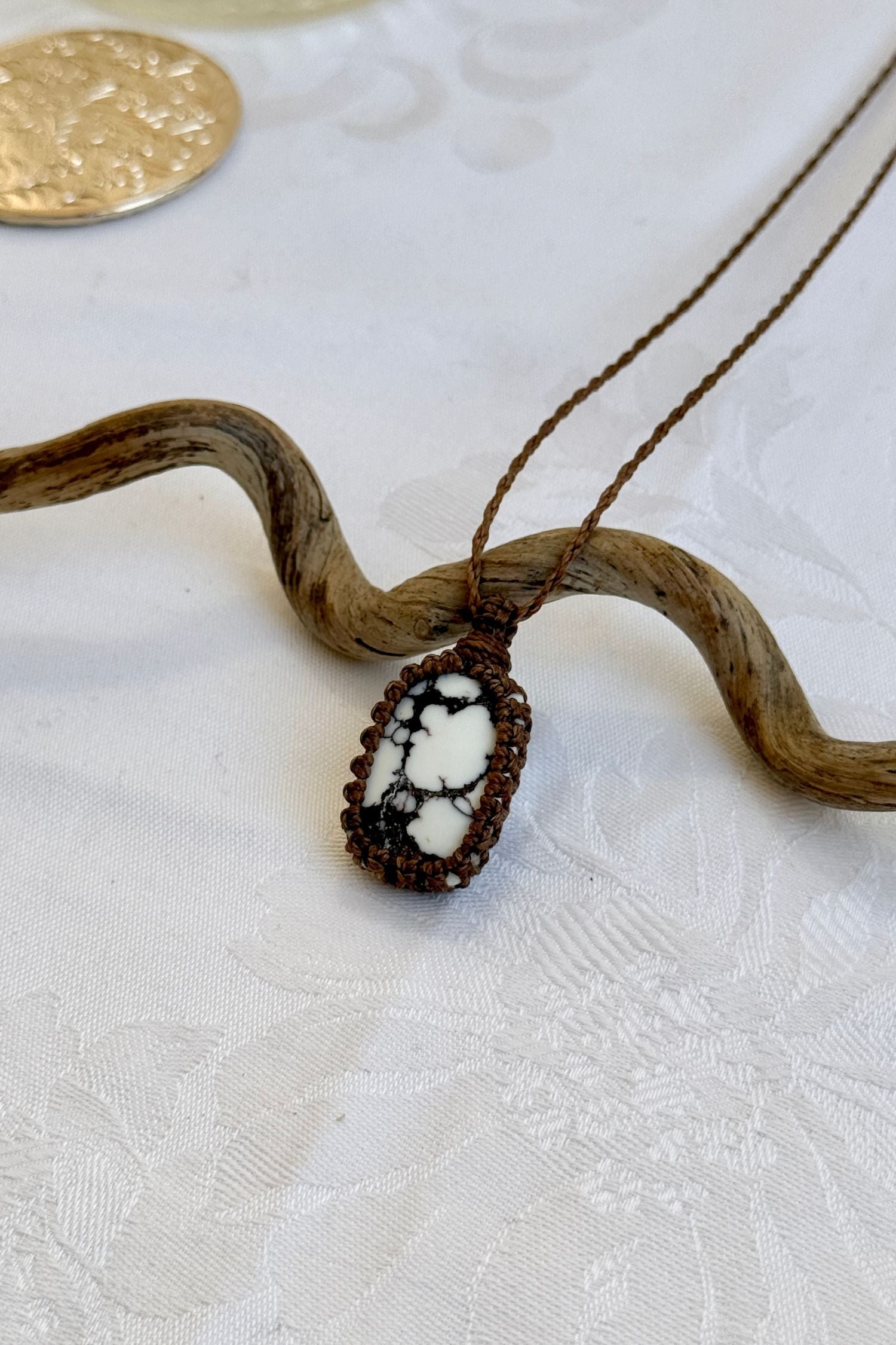 Side angle view of the Wild Horse Magnesite Macrame necklace, showing the fine macrame details and the unique gemstone centerpiece.