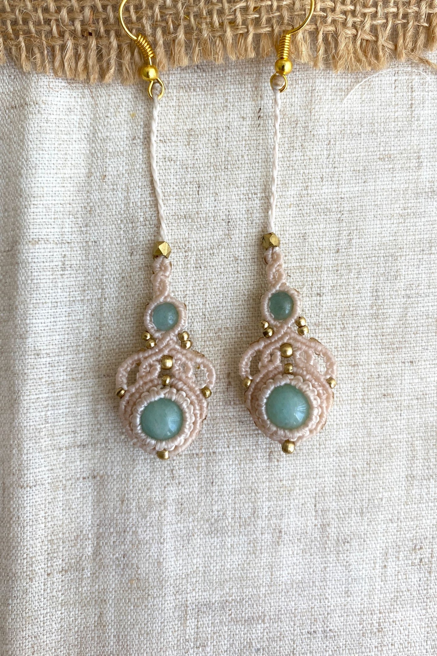Close-up view of handmade macrame earrings with amazonite and aquamarine gemstones, highlighting the intricate knotting and elegant design.