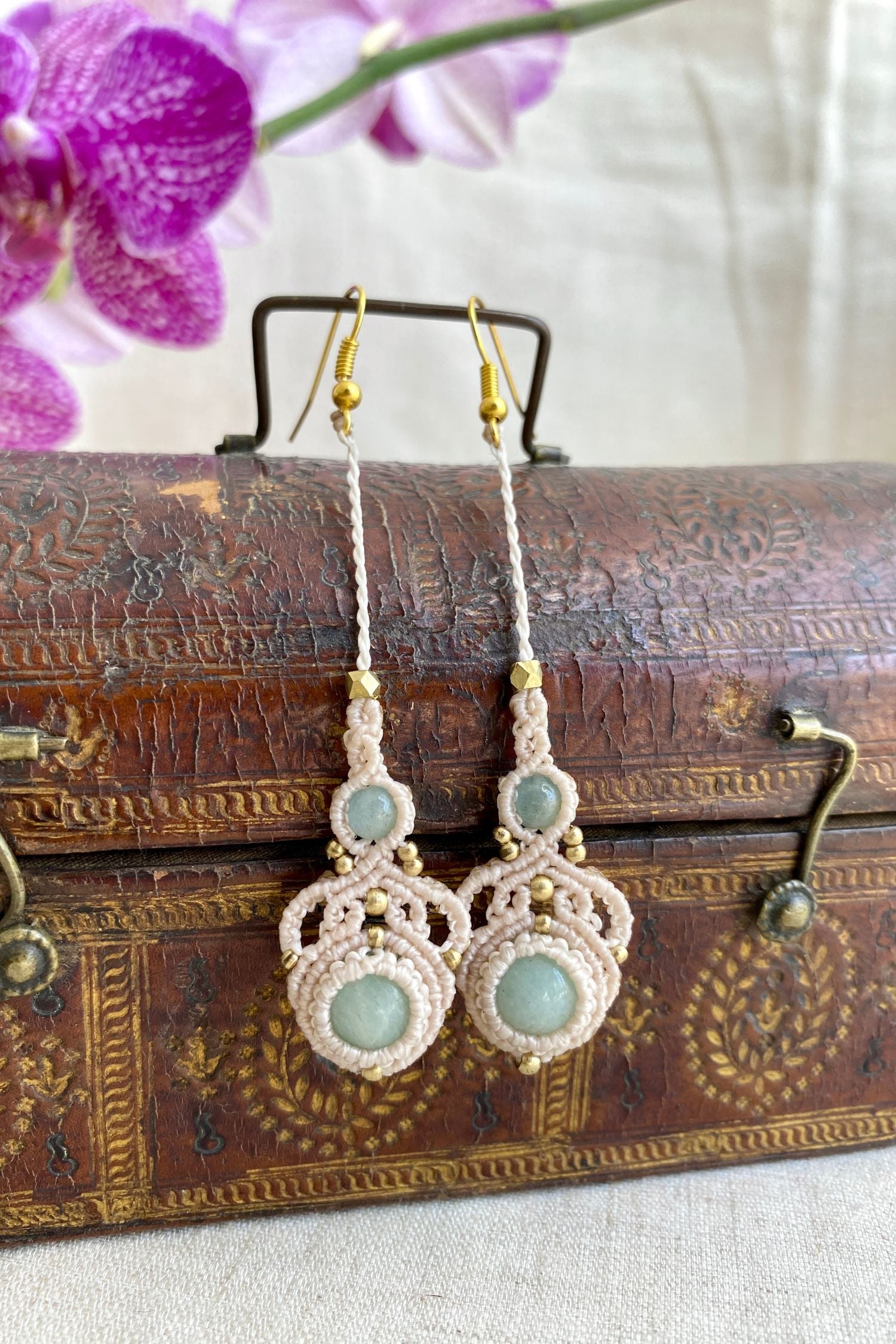 Artistic shot of handmade macrame earrings with amazonite and aquamarine gemstones, showcasing the elegant design and lightweight nature of the earrings.