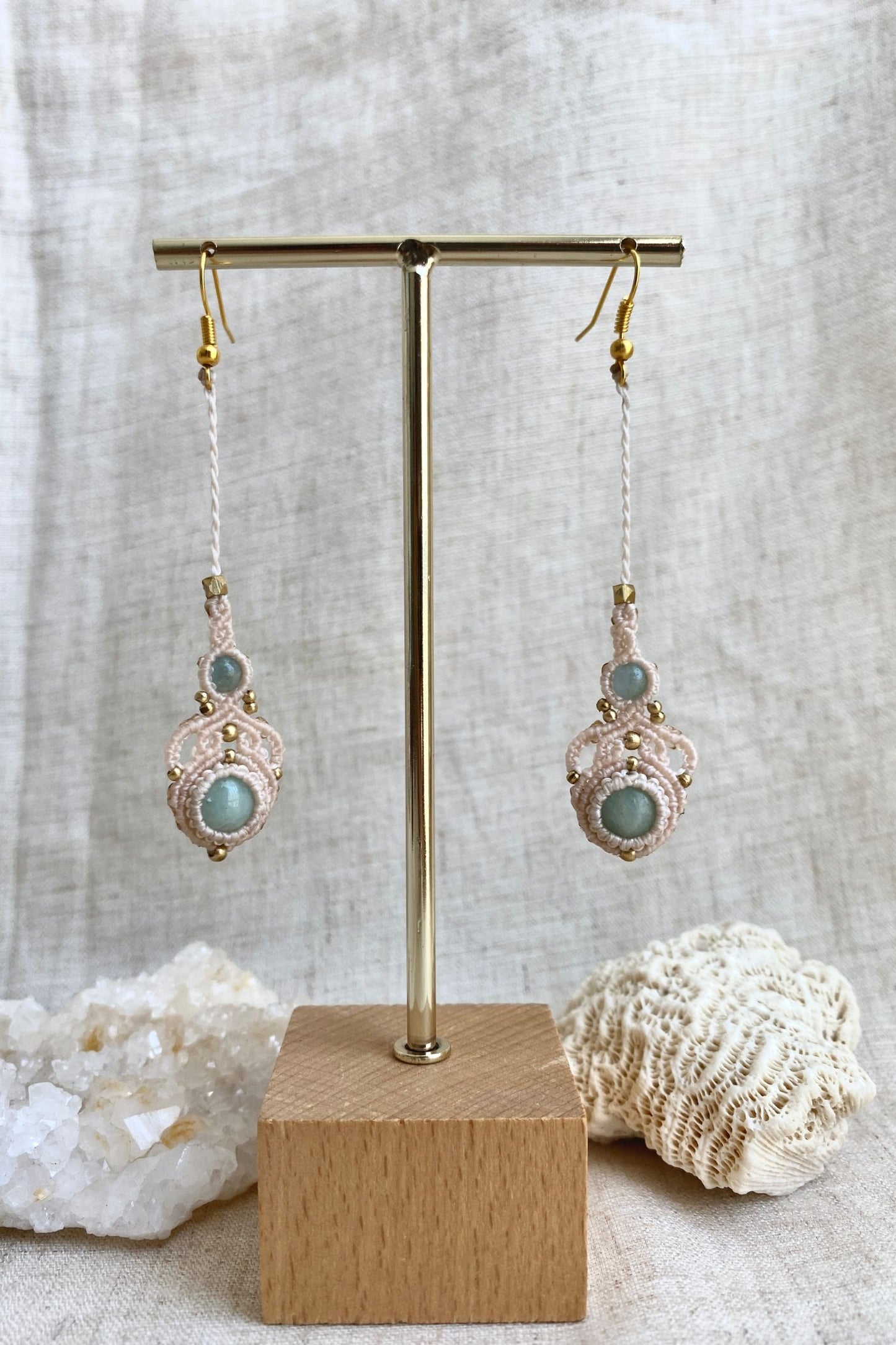 Handmade macrame earrings with amazonite and aquamarine gemstones displayed on an earring stand, emphasizing the elegant long drop design and gemstone contrast.