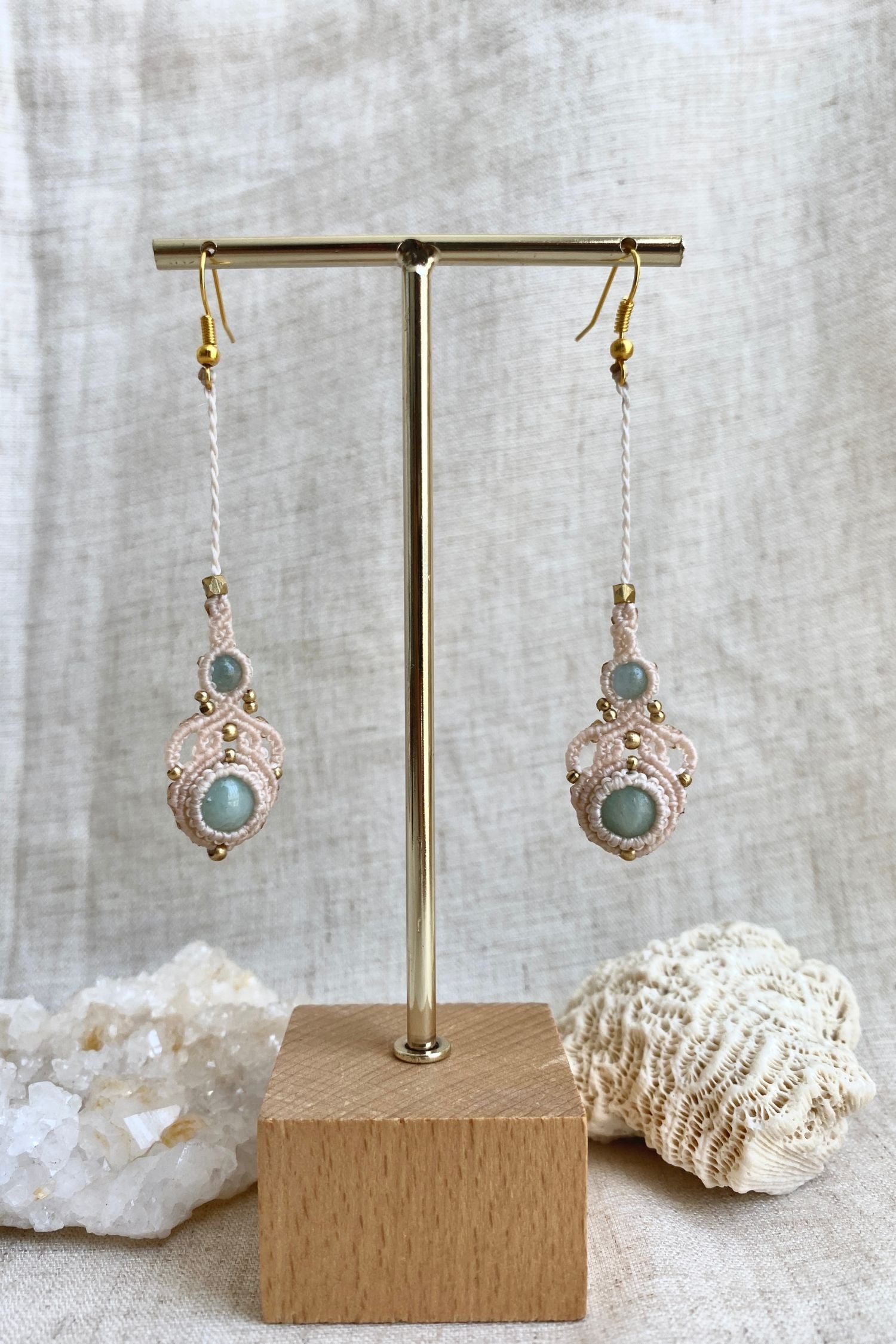 Handmade macrame earrings with amazonite and aquamarine gemstones displayed on an earring stand, emphasizing the elegant long drop design and gemstone contrast.