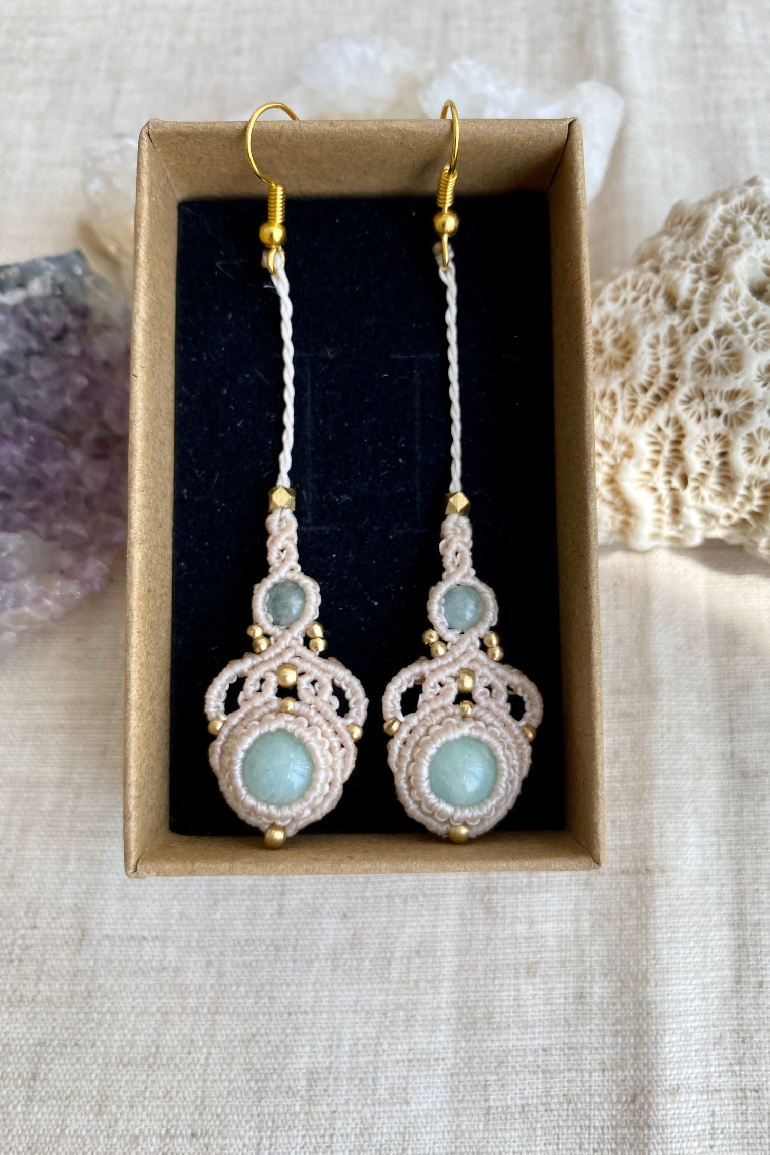 Handmade macrame earrings with amazonite and aquamarine gemstones, displayed in a box to highlight the contrast of the gemstones and intricate design.