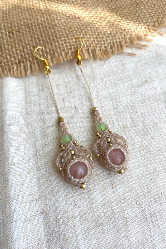 Handmade macrame earrings featuring rose quartz and prehnite gemstones, displayed laid flat to showcase the elegant long drop design.