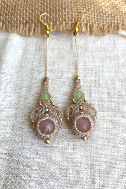 Close-up view of handmade macrame earrings with rose quartz and prehnite gemstones, highlighting the intricate knotting and elegant design.