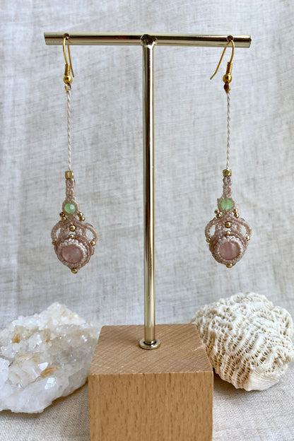 Handmade macrame earrings with rose quartz and prehnite gemstones displayed on an earring stand, emphasizing the elegant long drop design and gemstone contrast.