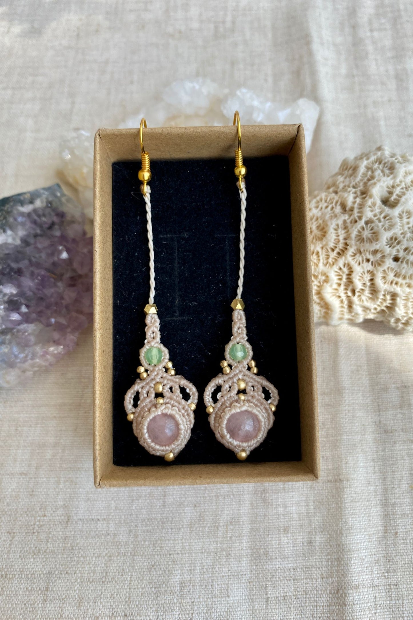 Handmade macrame earrings with rose quartz and prehnite gemstones, displayed in a box to highlight the contrast of the gemstones and intricate design.