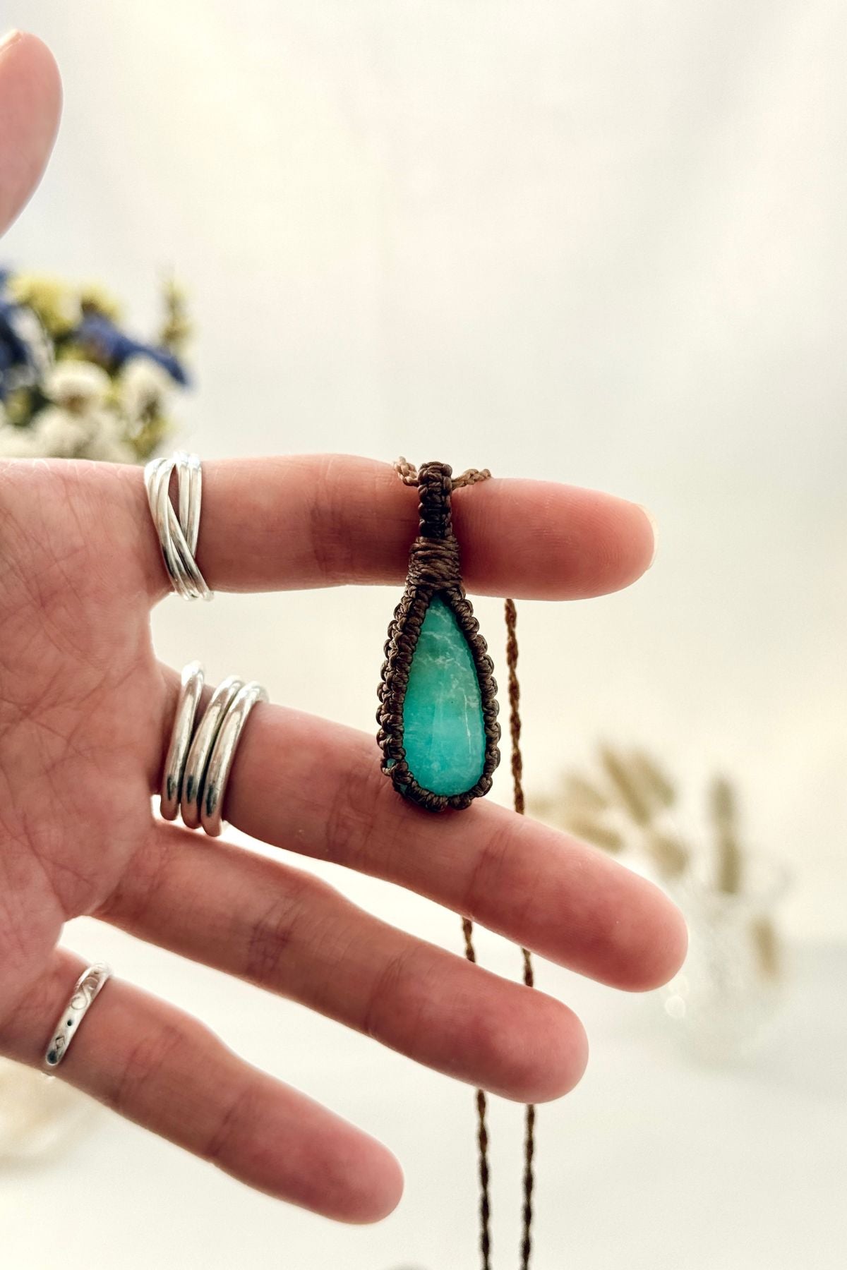Handmade Amazonite macramé necklace held in hand, delicate natural gemstone jewelry