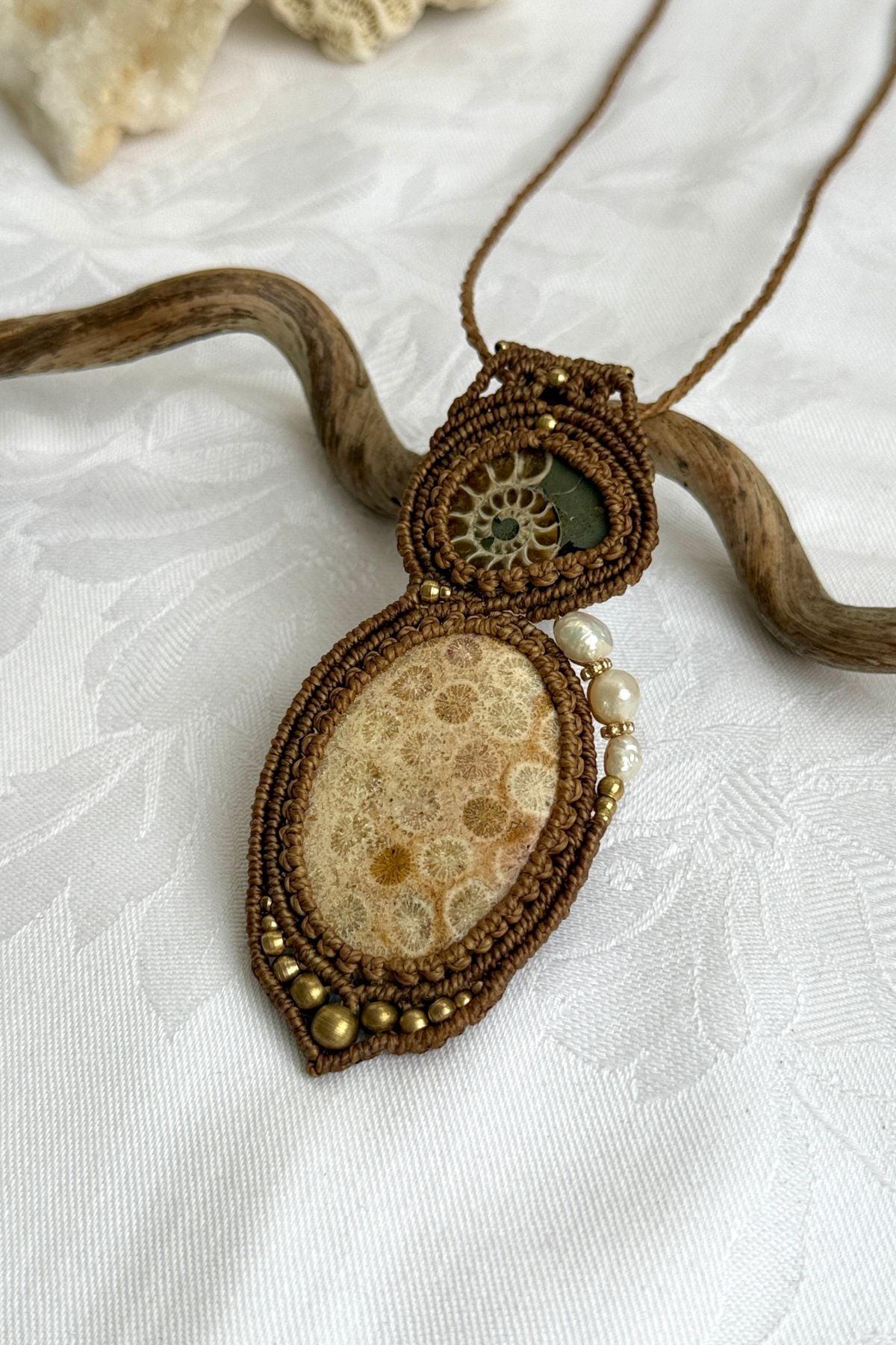 Detailed view of sliced ammonite fossil necklace with organic textures and asymmetrical design.
