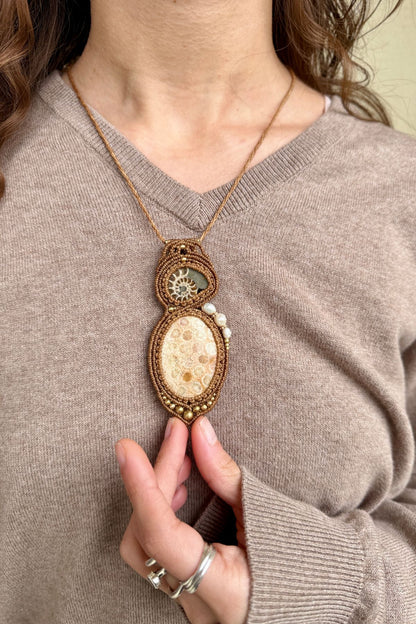 Model wearing rare sliced ammonite and fossil coral statement necklace, luxury ocean inspired jewelry.