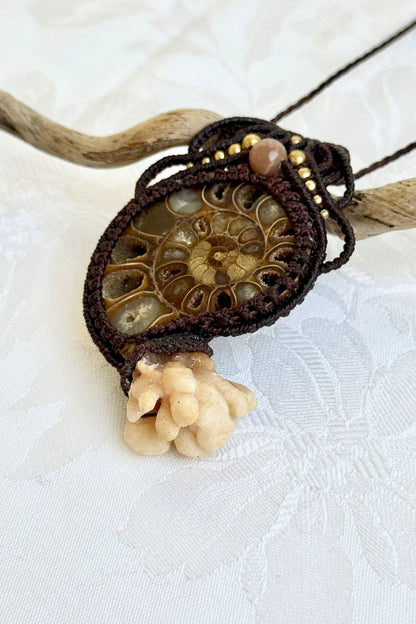 Close-up showing exquisite macramé craftsmanship holding calcite coraloid tentacles securely to ammonite fossil in statement necklace