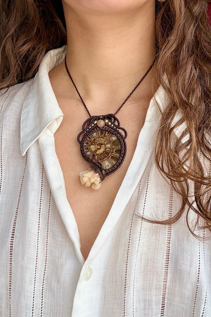 Model wearing ammonite fossil pendant necklace with calcite coraloid tentacles and peach moonstone in ocean inspired design
