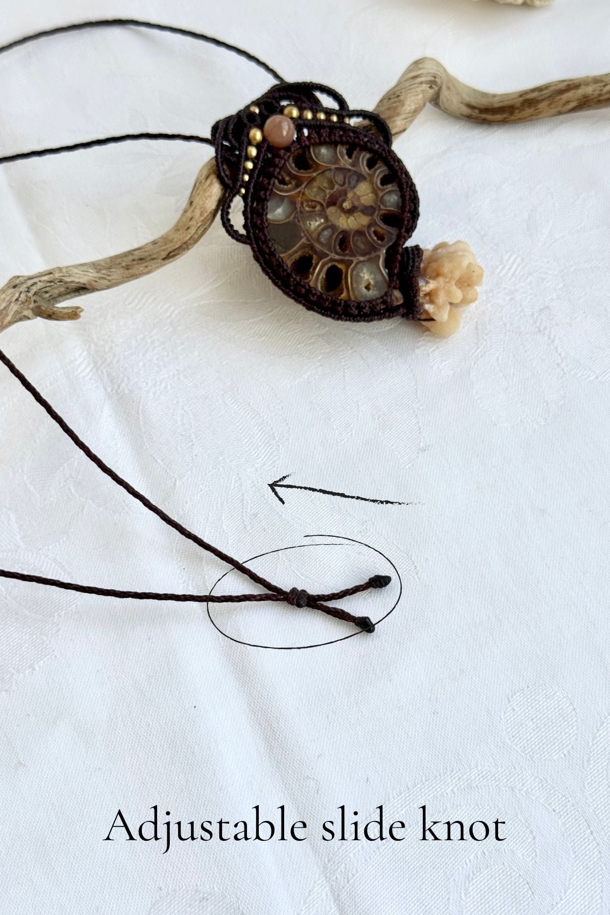 Detail of adjustable slide knot on ammonite fossil pendant necklace allowing versatile fit from close to neck to longer V-shaped silhouette