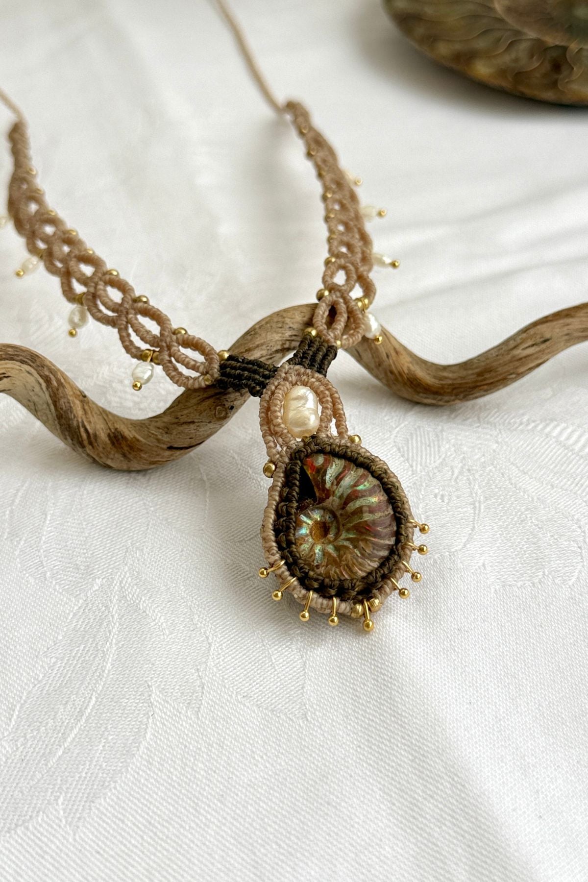 Detailed view of shimmering ammonite surface and delicate pearl drop accents