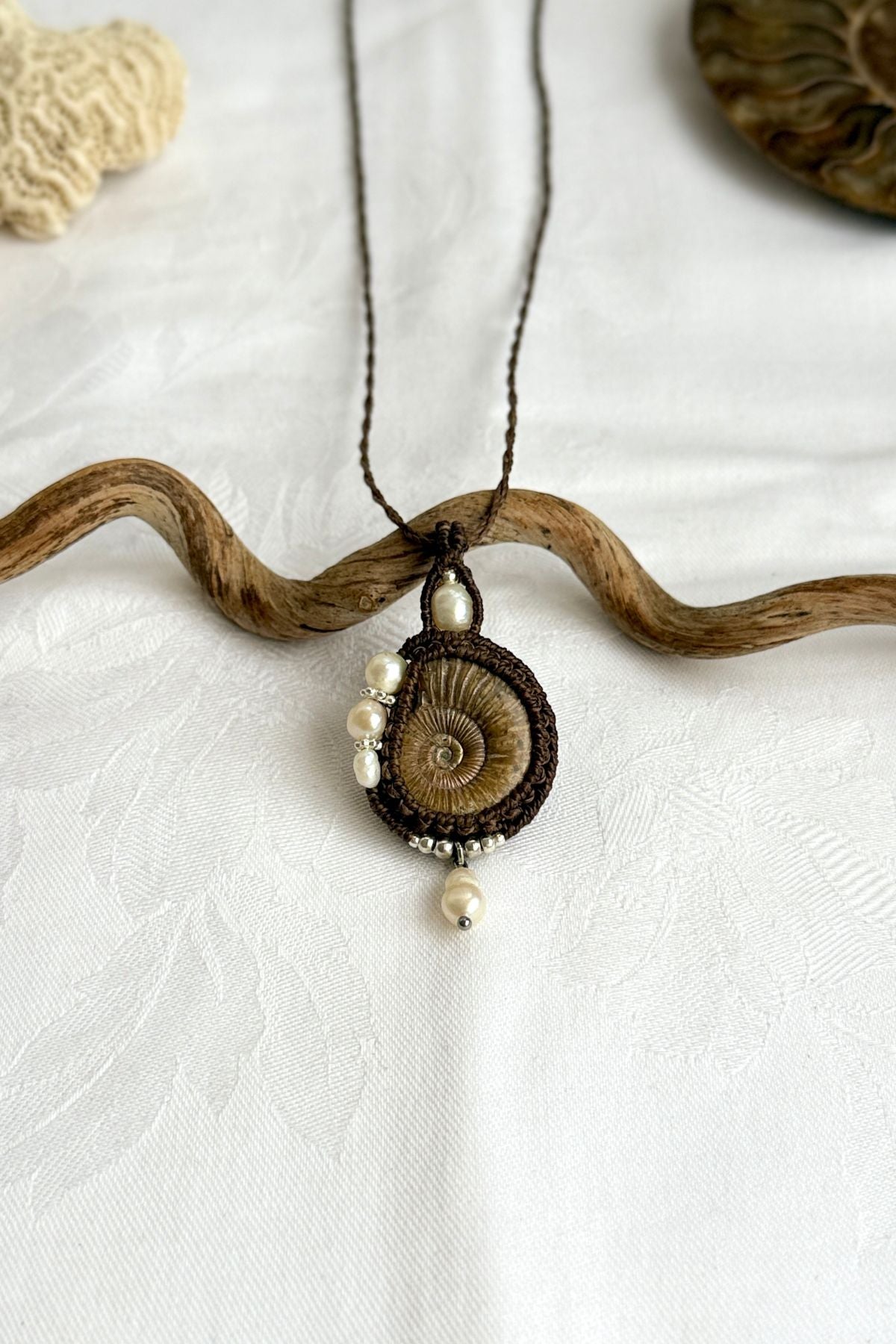 Close-up of spiral ammonite with freshwater pearls, natural history jewelry