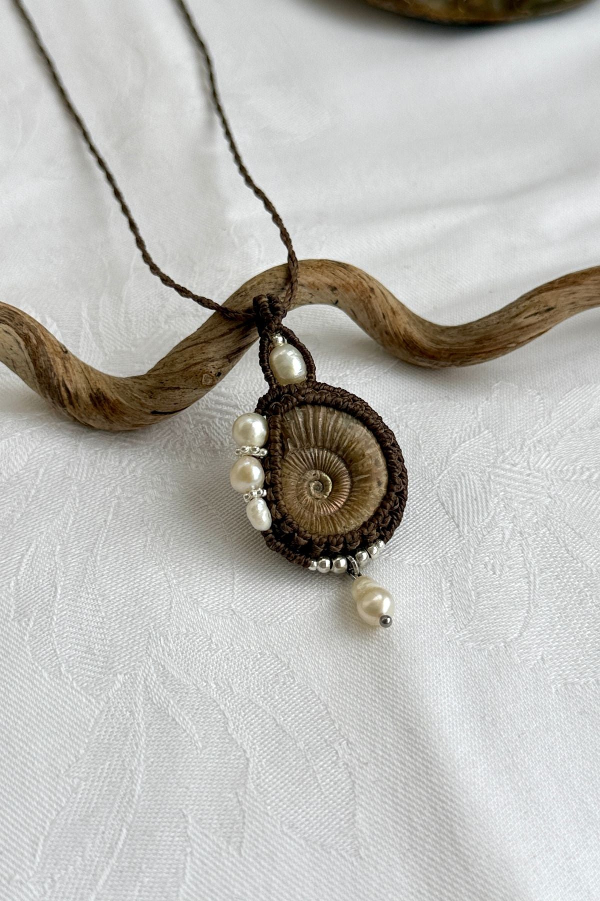 Detailed view of raw ammonite fossil necklace with organic textures and asymmetrical design