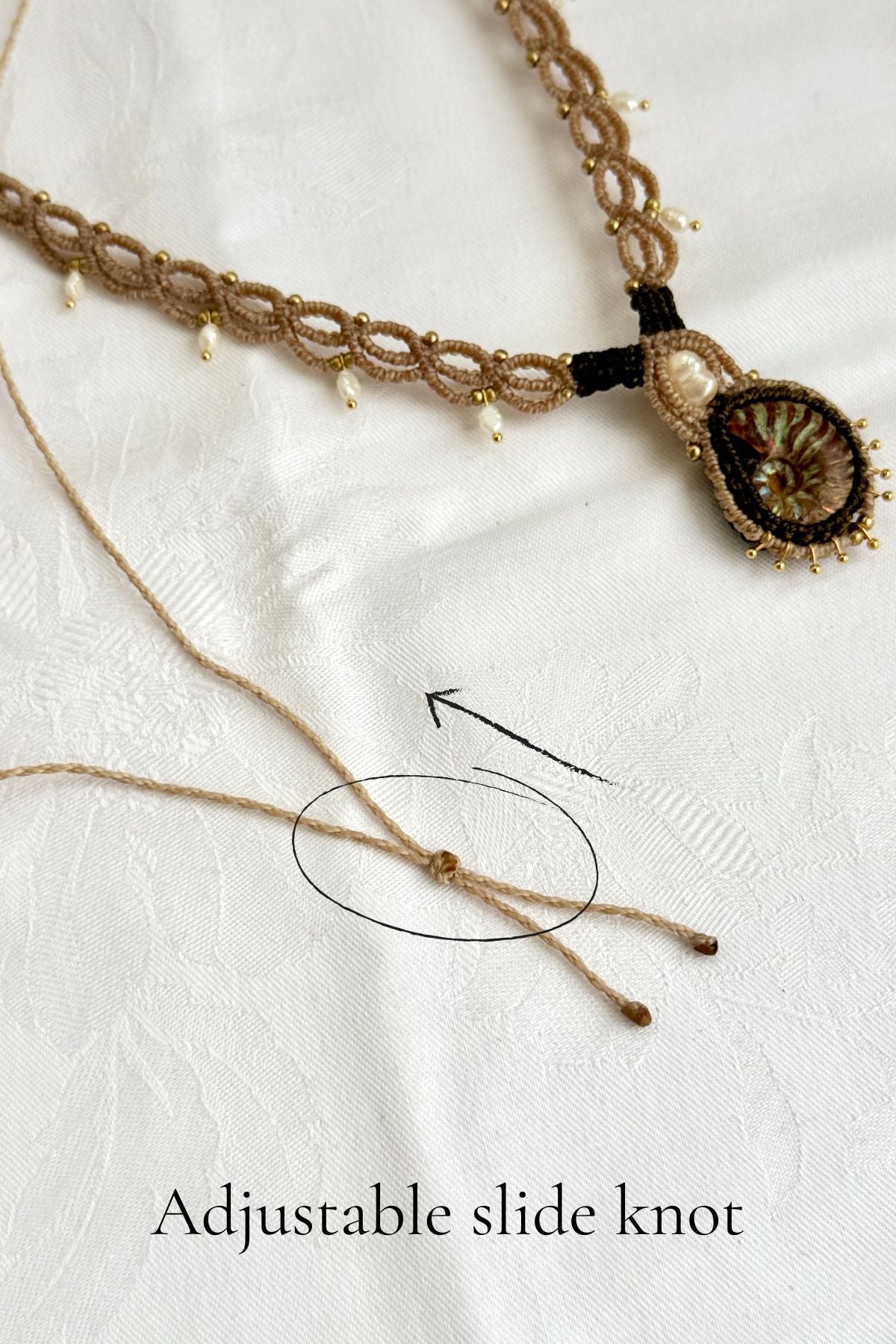 Adjustable sliding knot closure on iridescent ammonite fossil necklace