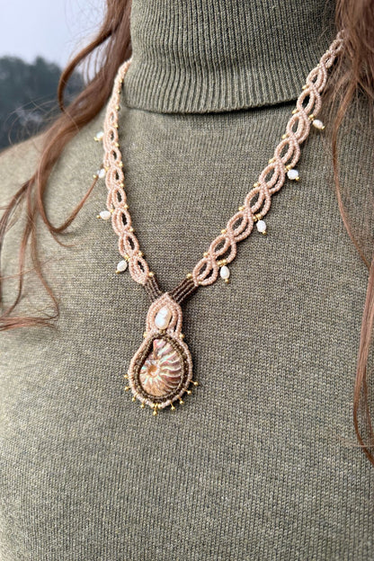 Model wearing iridescent ammonite and freshwater pearl statement necklace, bold ocean inspired jewelry