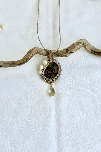 One of a kind ammonite fossil necklace with freshwater pearls and lemon quartz drop on neutral background