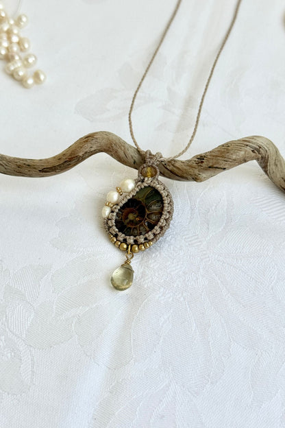 Close-up of asymmetric freshwater pearl detail on ammonite fossil necklace with natural gemstone accents