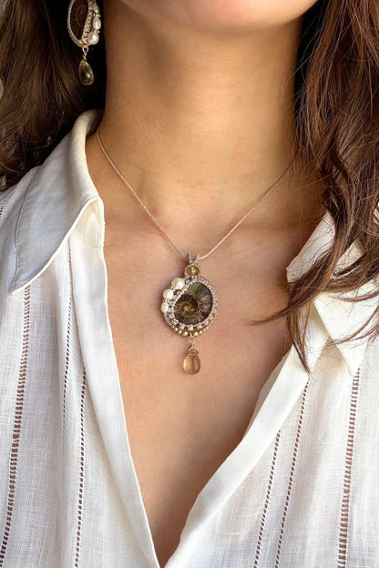 Model wearing ammonite fossil necklace with freshwater pearls and lemon quartz drop, ocean inspired statement jewelry
