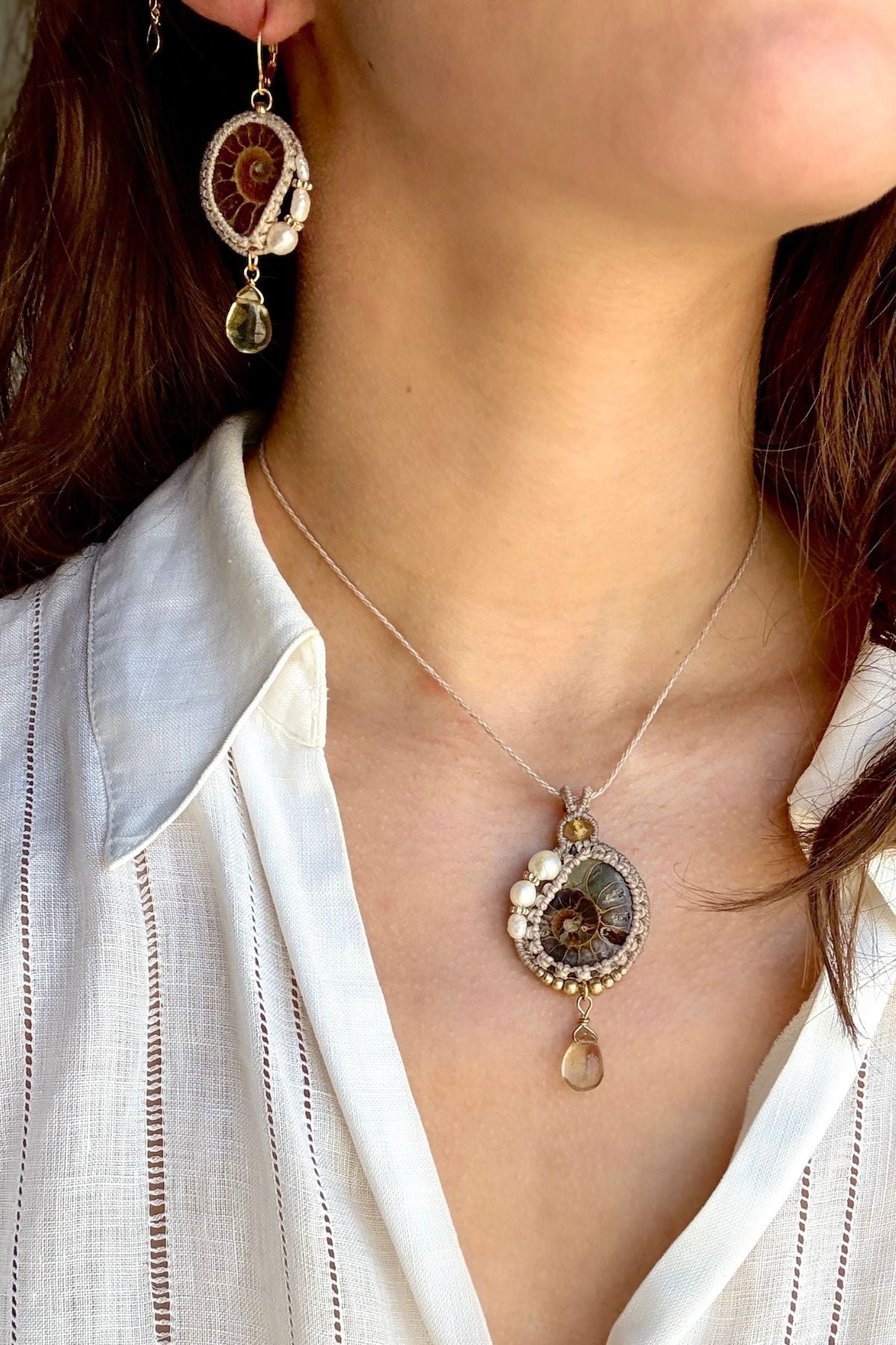 Model wearing ammonite fossil necklace paired with matching ammonite and pearl earrings for an ocean inspired set