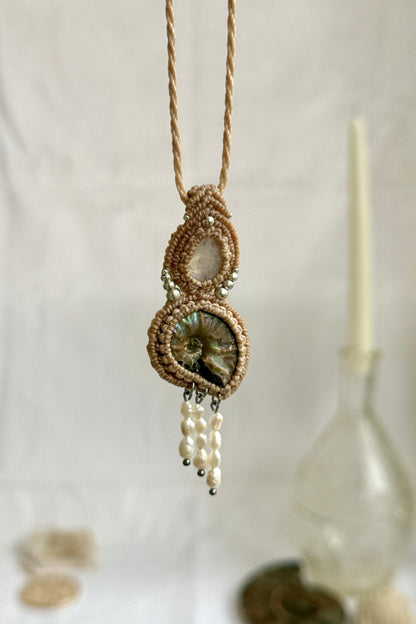 Opalized ammonite and moonstone statement necklace hanging to showcase dangling freshwater pearl drops