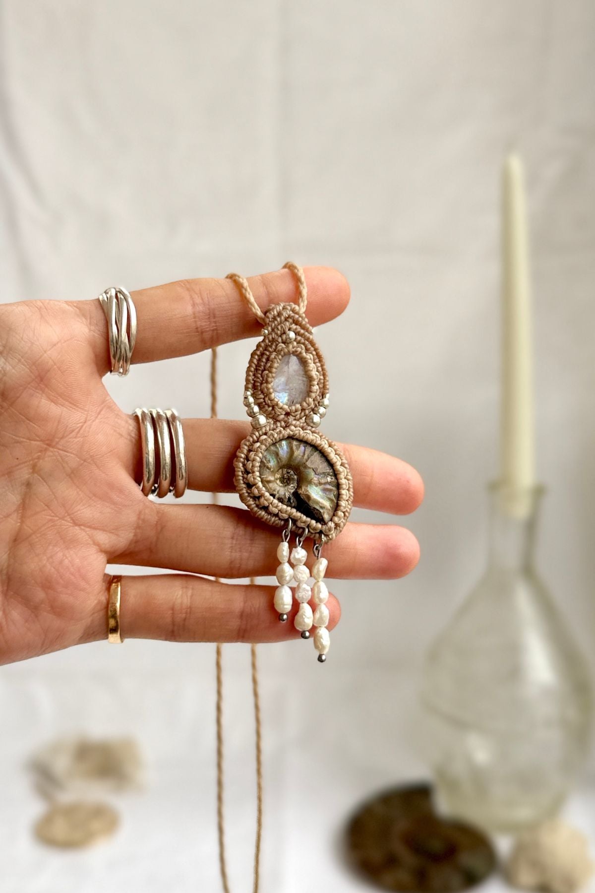 Opalized ammonite fossil necklace with natural moonstone shown in hand