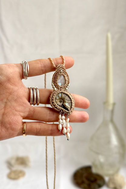 Opalized ammonite fossil necklace with natural moonstone shown in hand