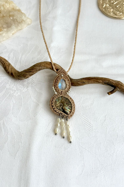 Detailed top view of iridescent ammonite with ocean blue moonstone and pearl accents