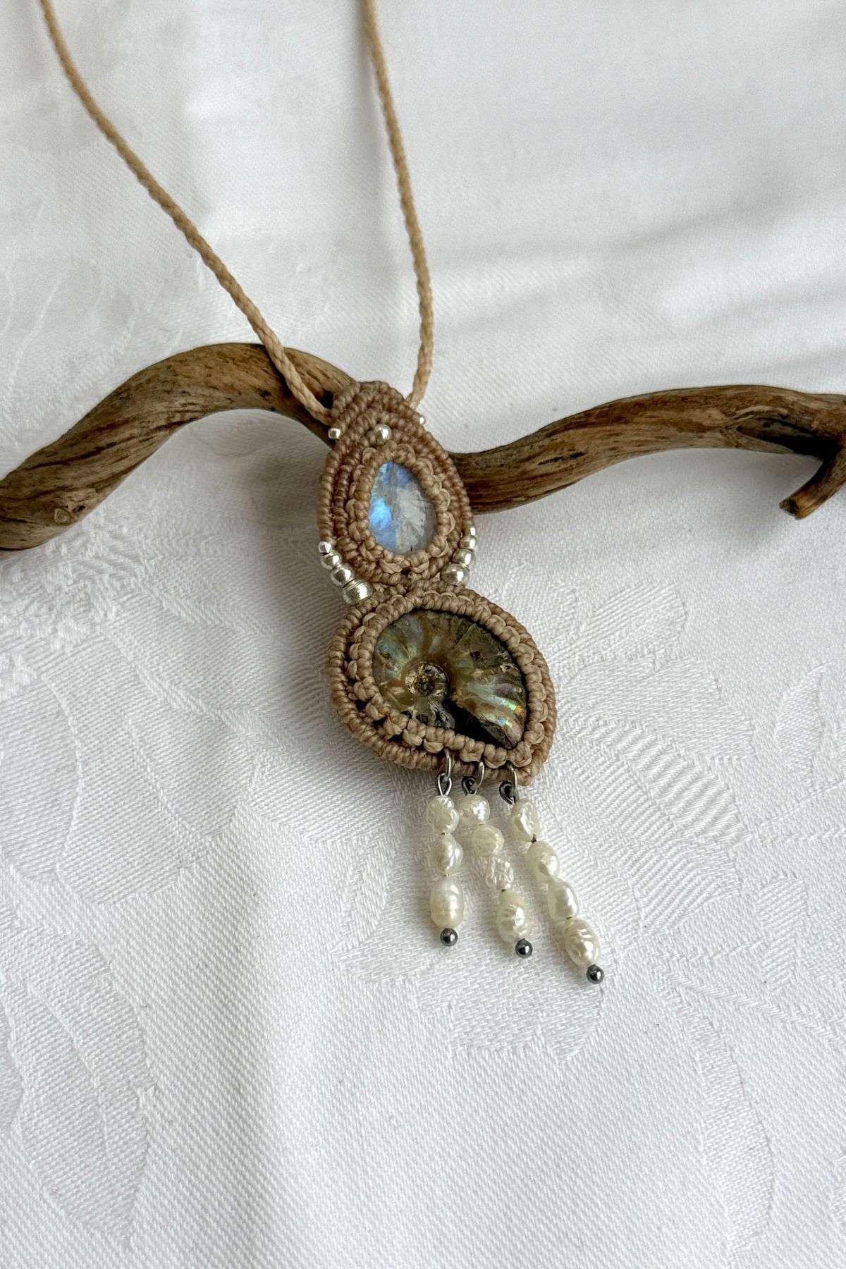 Close-up of opalized ammonite surface with natural iridescence, moonstone and freshwater pearls