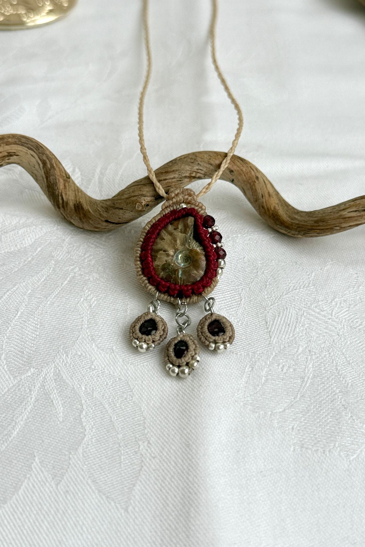 Natural ammonite fossil necklace with faceted garnet accents and three dangling garnet drops