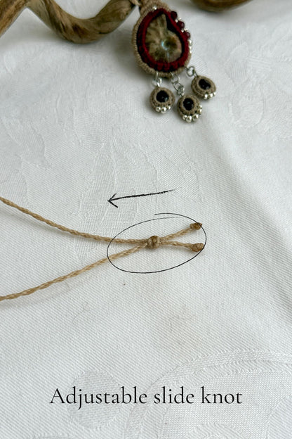 Adjustable sliding knot closure on ammonite and garnet fossil necklace