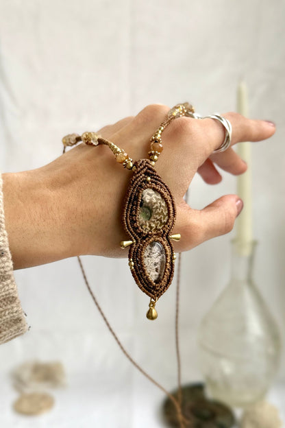 Rare patterned ammonite and lodolite necklace shown over hand, with faceted rutilated quartz beads