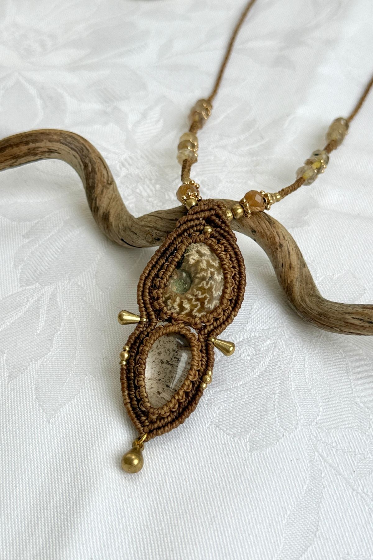 Detailed view of lodolite “landscape stone” and patterned ammonite with faceted rutilated quartz accents