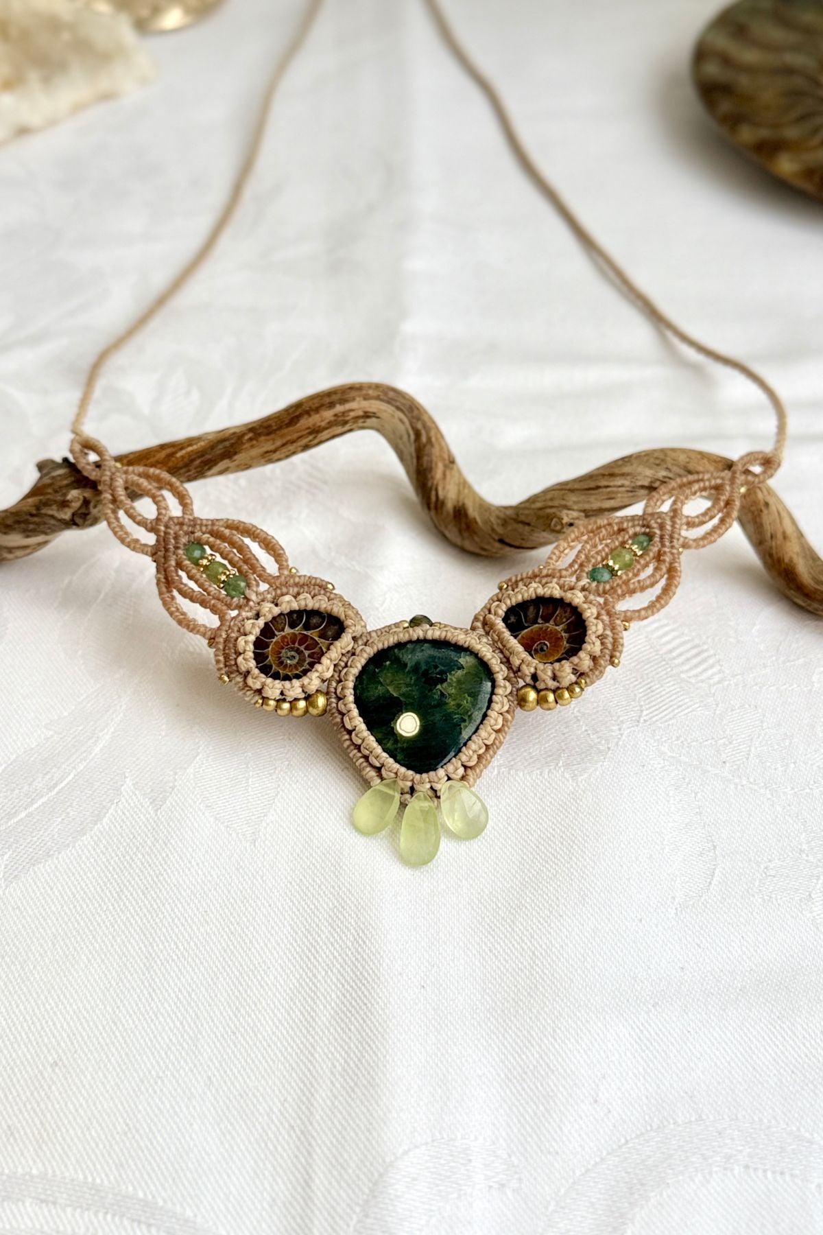 Close-up of Madagascar ocean jasper “eye” with split ammonite and green tourmaline bead details