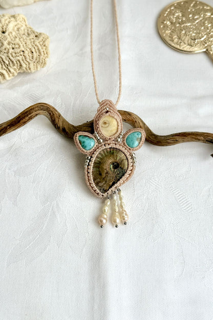 Detailed top view of iridescent ammonite with ocean blue larimar and pearl accents