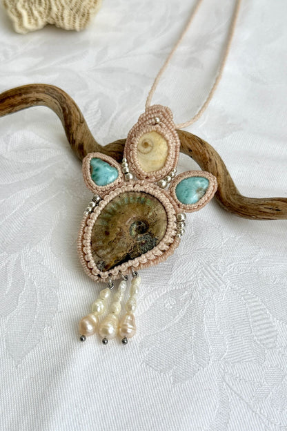 Close-up of opalized ammonite surface with natural iridescence, larimar drops and freshwater pearls
