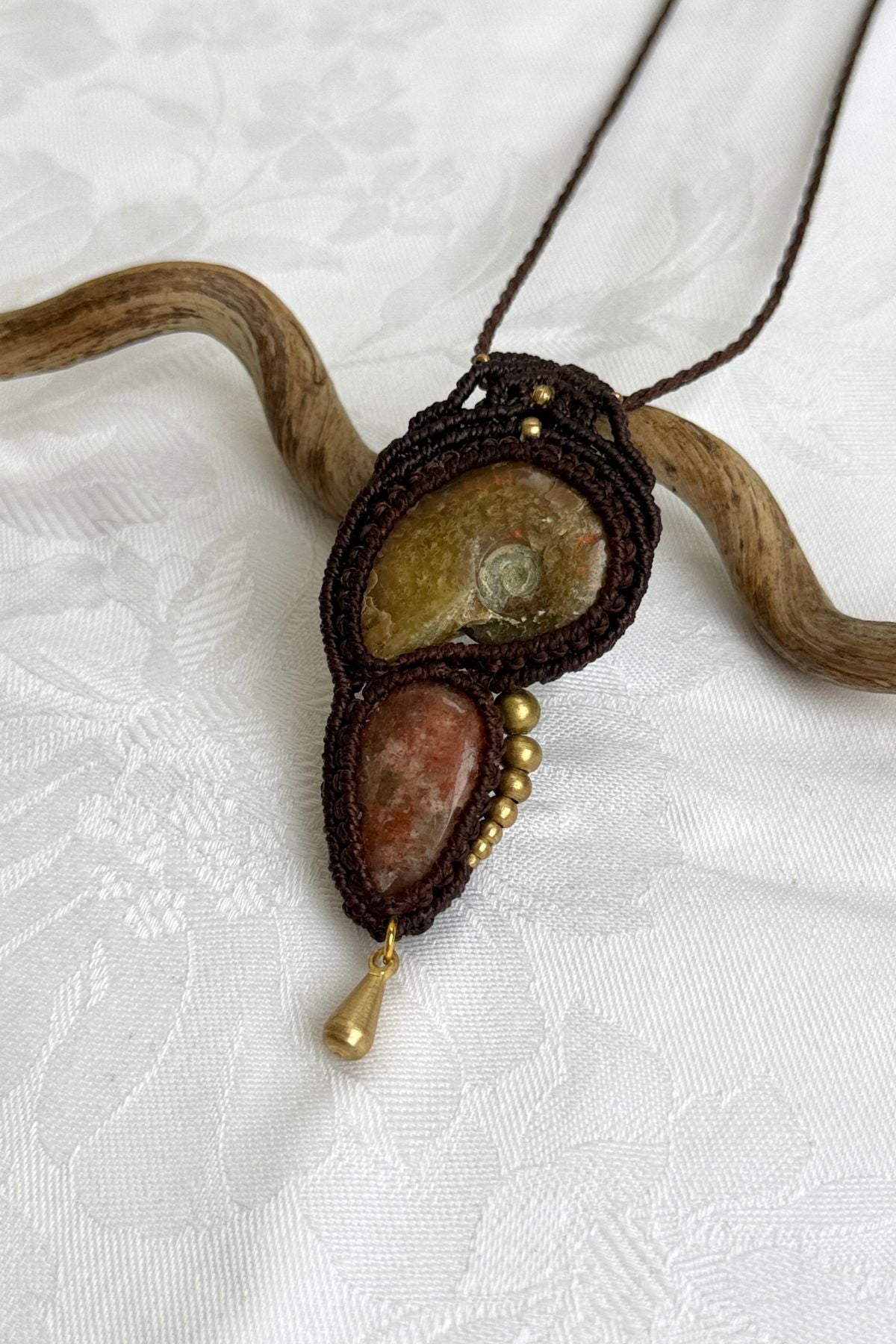 Close-up of opalized ammonite surface with natural iridescence, sunstone sparkle, and brass drop detail