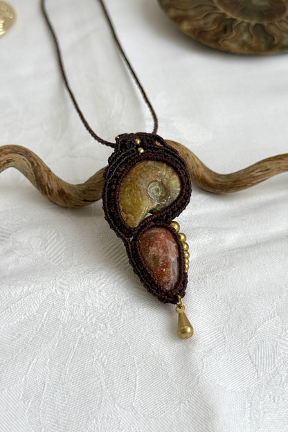 Detailed view of asymmetric bead pattern, opalized ammonite, and sparkling sunstone in one of a kind pendant