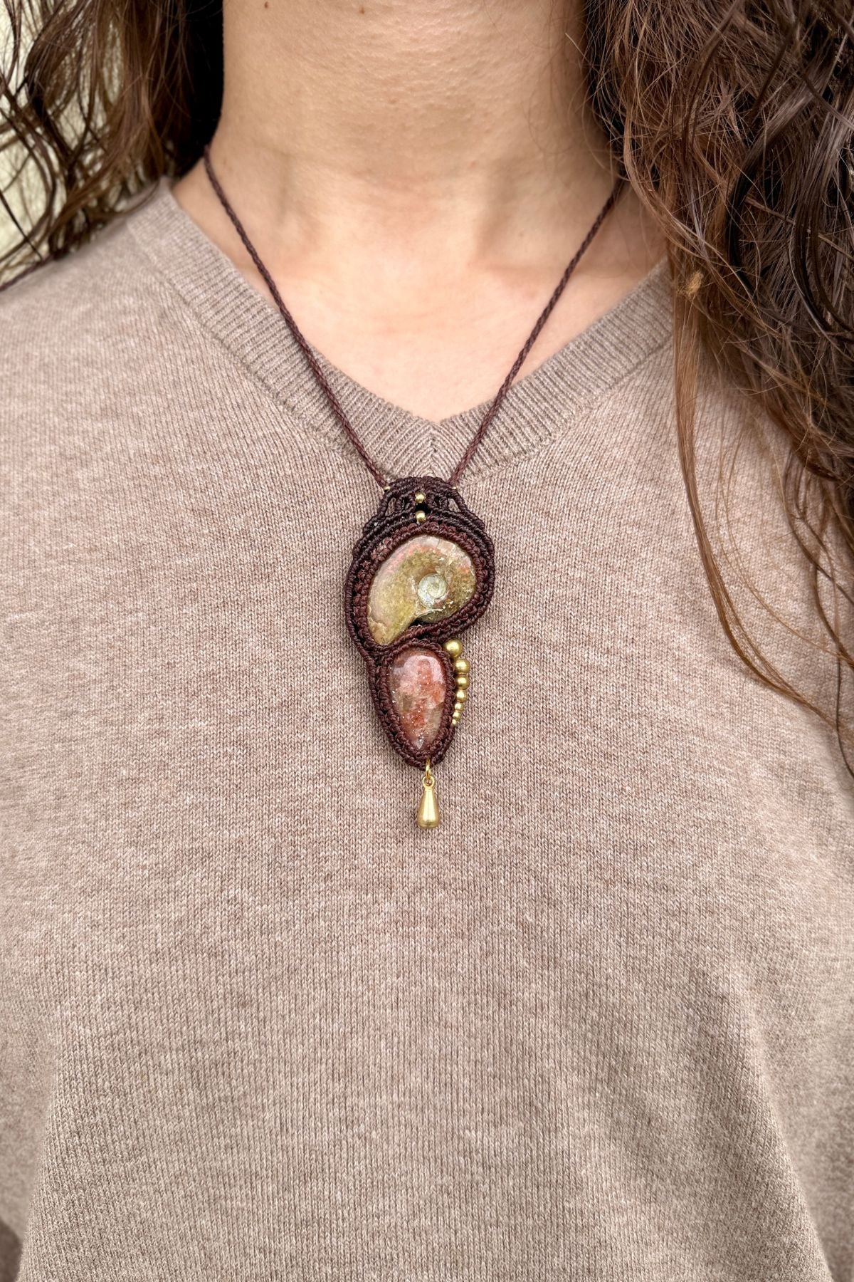 Model wearing opalized ammonite and sunstone pendant necklace, unique artisan statement jewelry