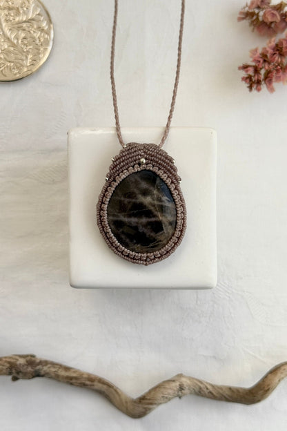 Handmade macrame necklace with Black Moonstone gemstone, part of the Nocturnal Collection. One-of-a-kind design, laid flat for an artistic display.