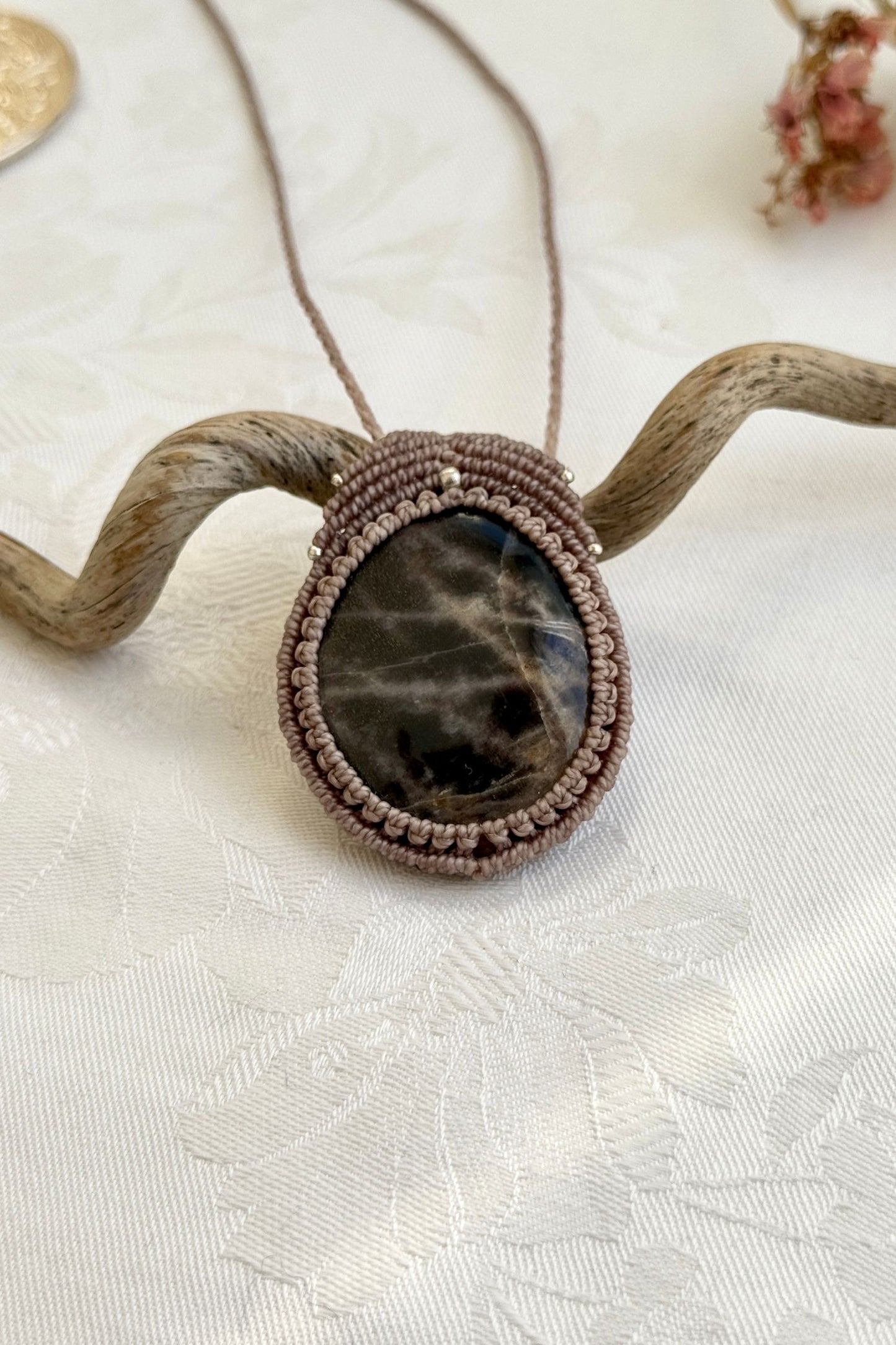  Close-up of the Black Moonstone macrame necklace in a unique setting. Highlighting the craftsmanship and gemstone details.