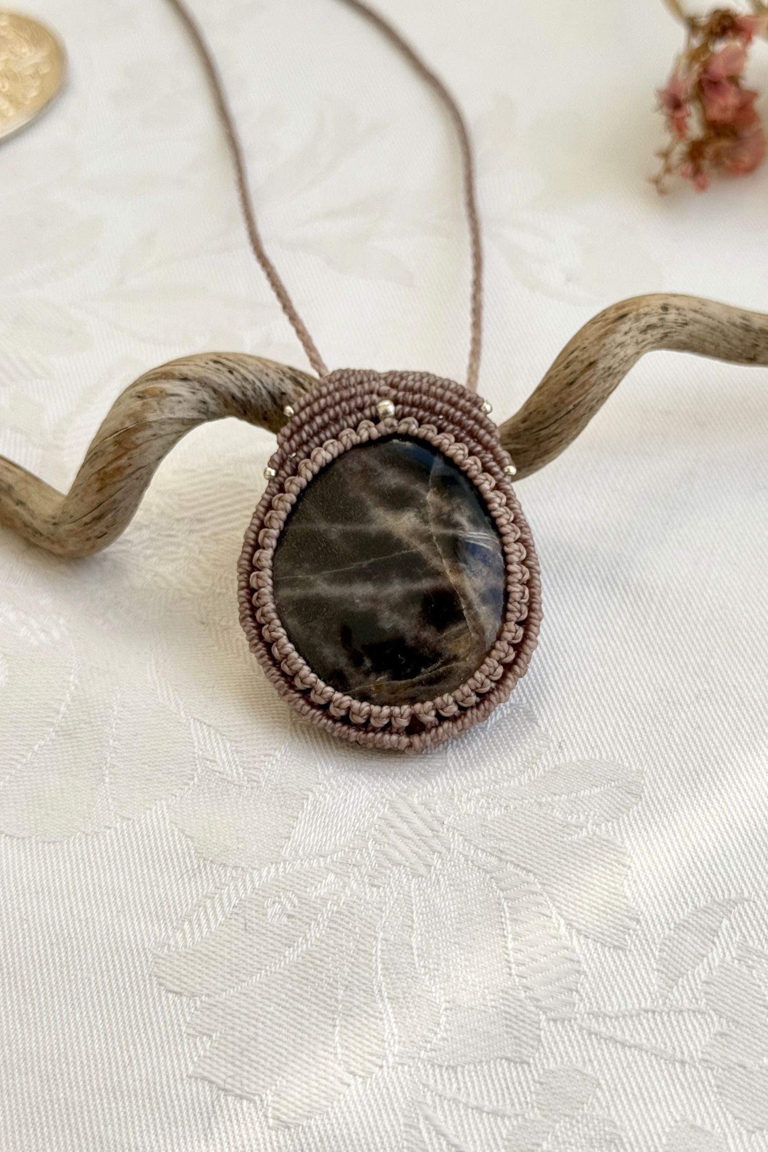  Close-up of the Black Moonstone macrame necklace in a unique setting. Highlighting the craftsmanship and gemstone details.