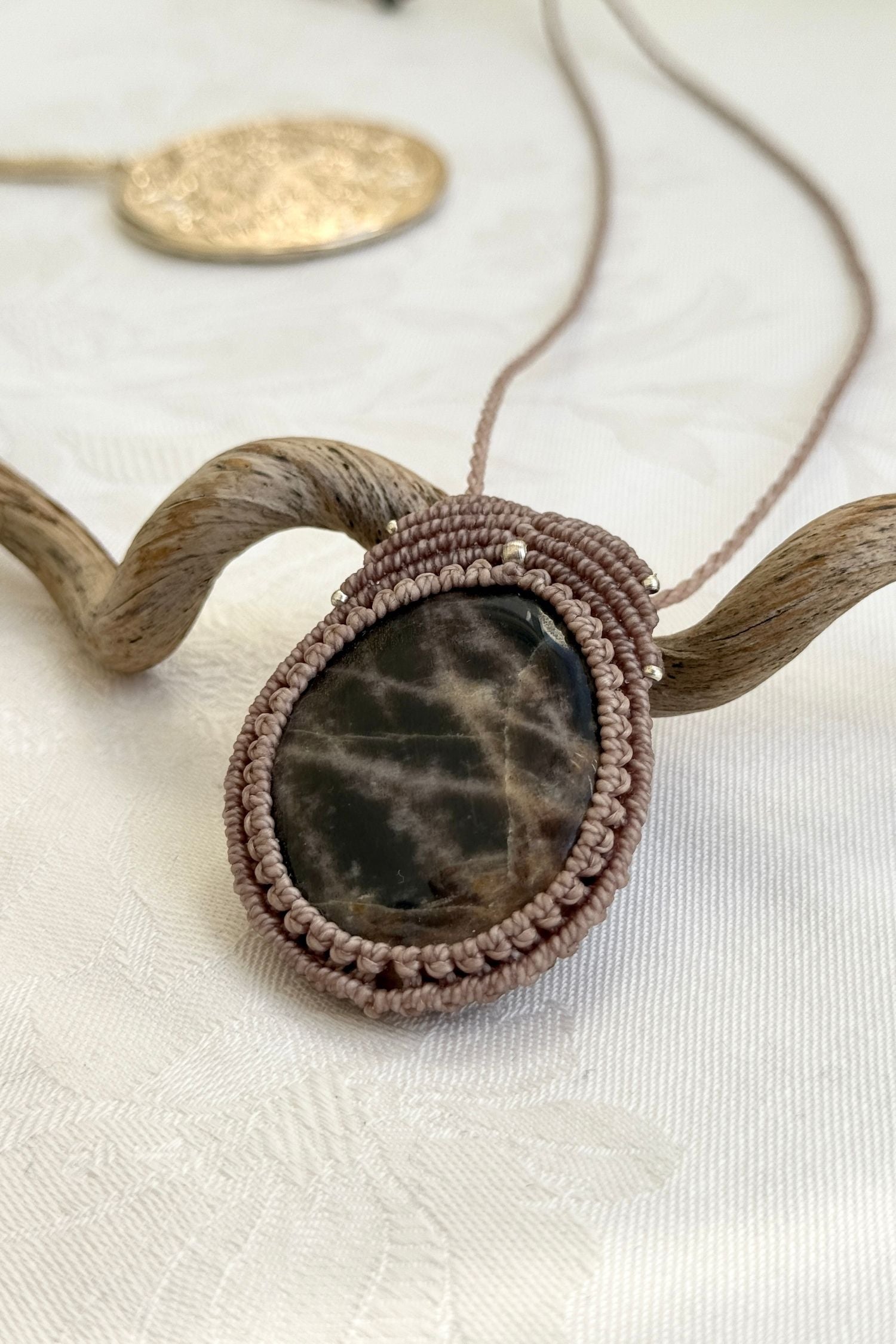 Side-angle view of the handmade macrame necklace with Black Moonstone. Showcasing depth, knotting details, and stone textures.