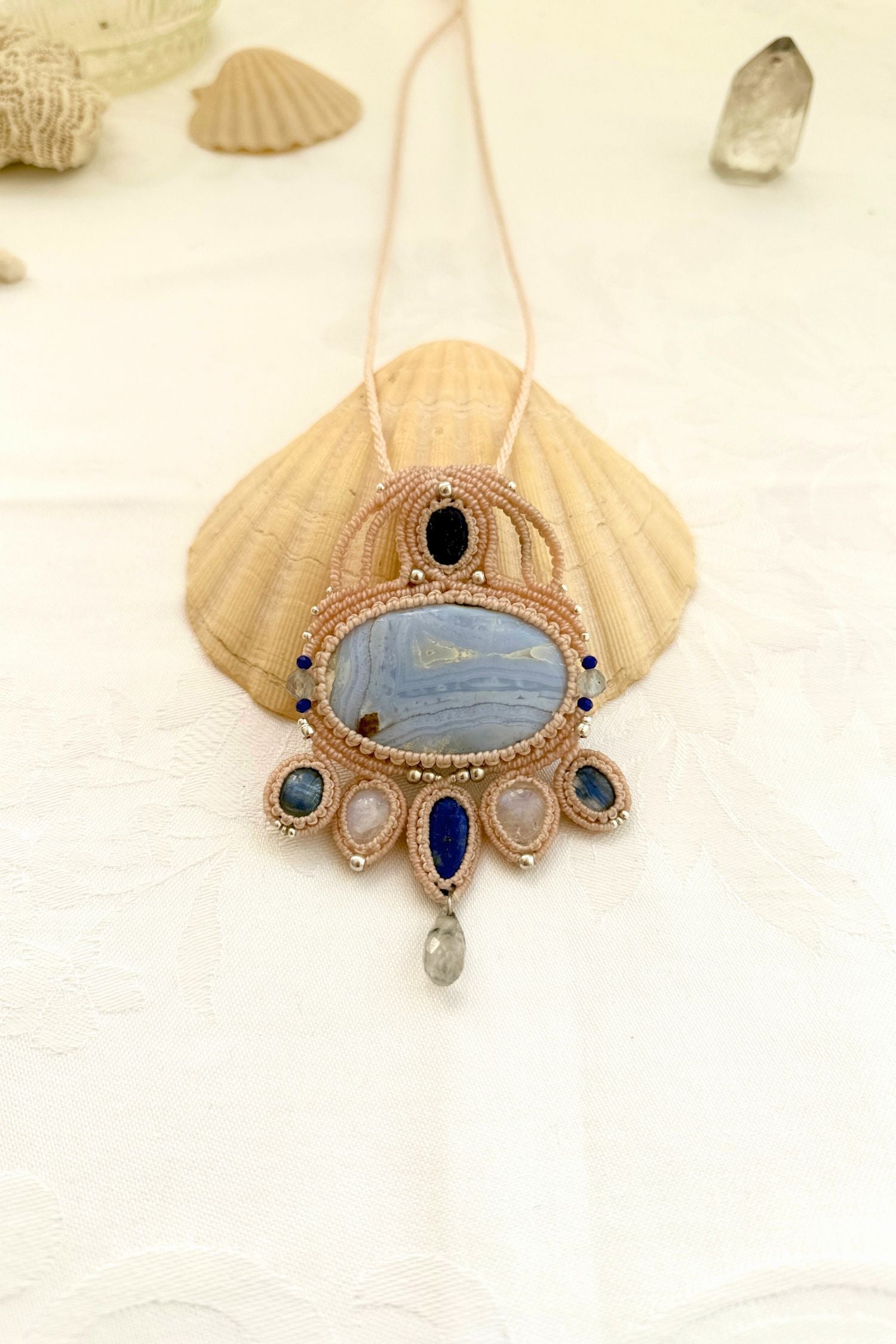 Close-up of a one of a kind gemstone macrame statement necklace featuring Blue Lace Agate, Lapis Lazuli, Moonstone, Kyanite, and silver details