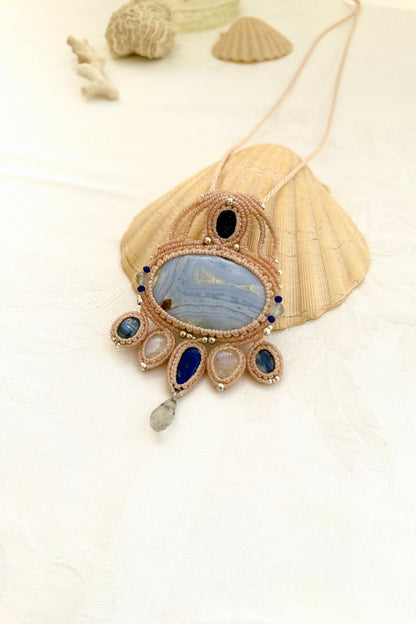 Side view of a handmade gemstone macrame necklace showing layered design, silver bead accents, and balanced stone placement