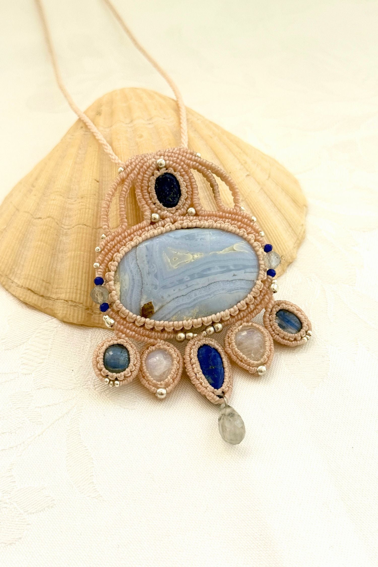 Angled side view of a one of a kind macrame statement necklace with Moonstone, Kyanite, and Lapis Lazuli details