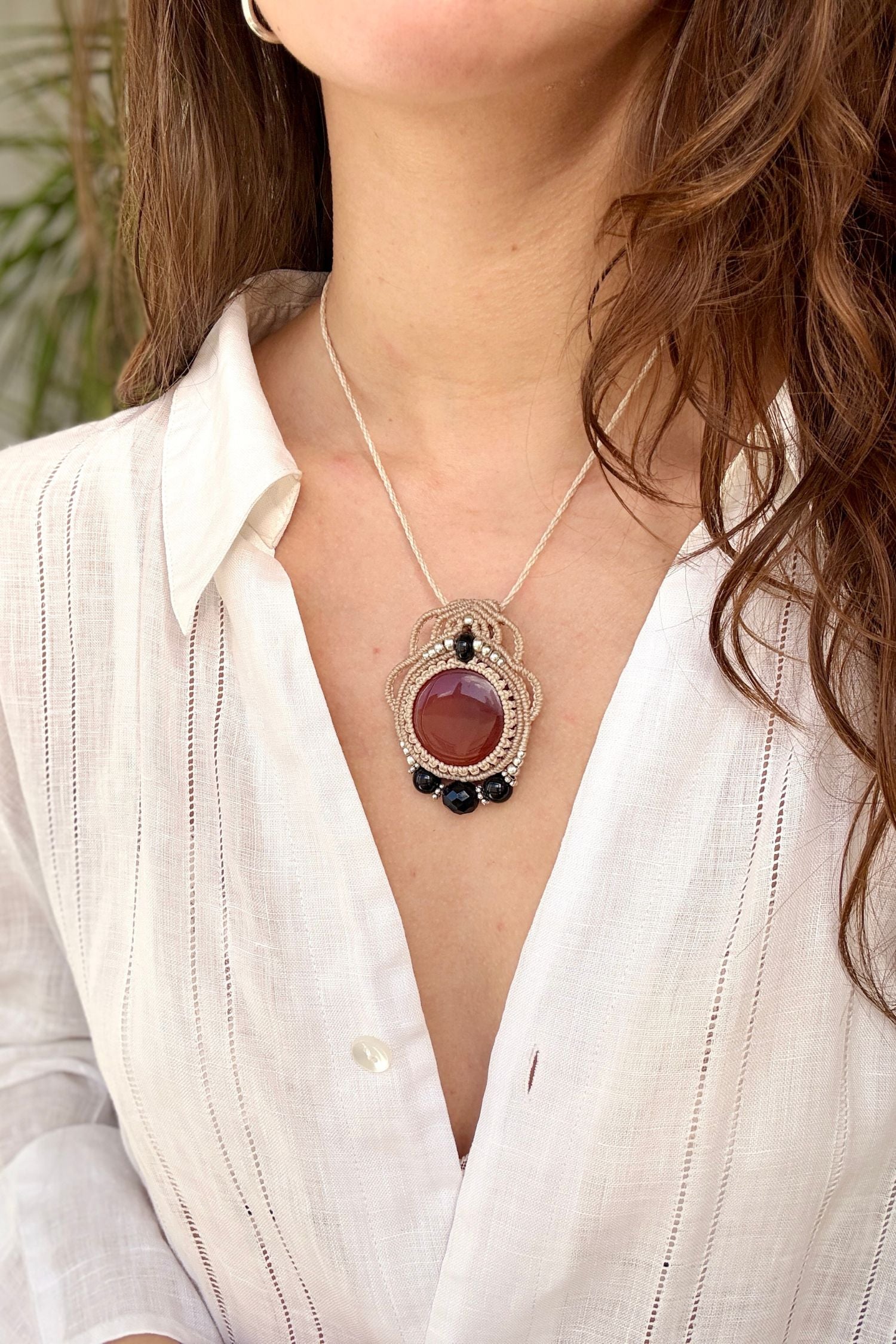 Round Carnelian and Onyx macrame necklace worn by a model. Showcasing the unique handmade design and how it looks when worn.